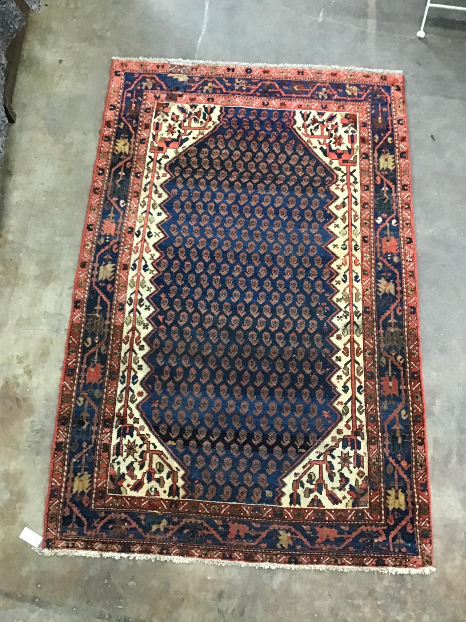 A North West Persian blue ground rug woven with rows of boteh, 196cm x 126cm